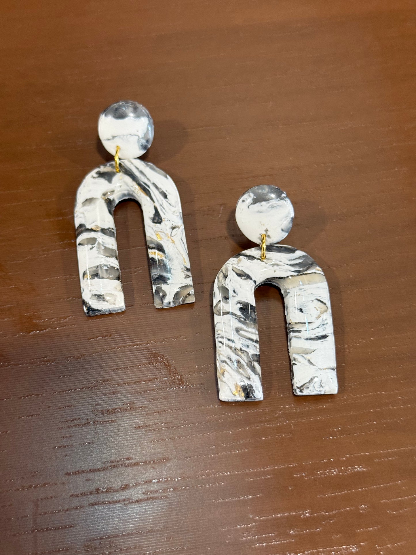 Black and white handmade polymer clay arch earrings with marbled design